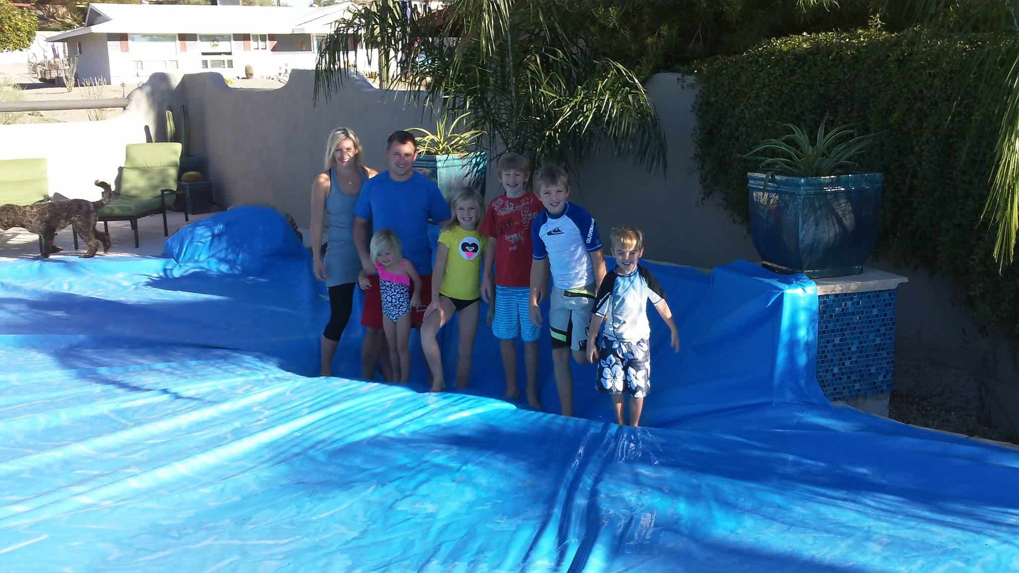 Arizona family standing on blue PowerLock safety pool cover by Solar Safe Pool Covers