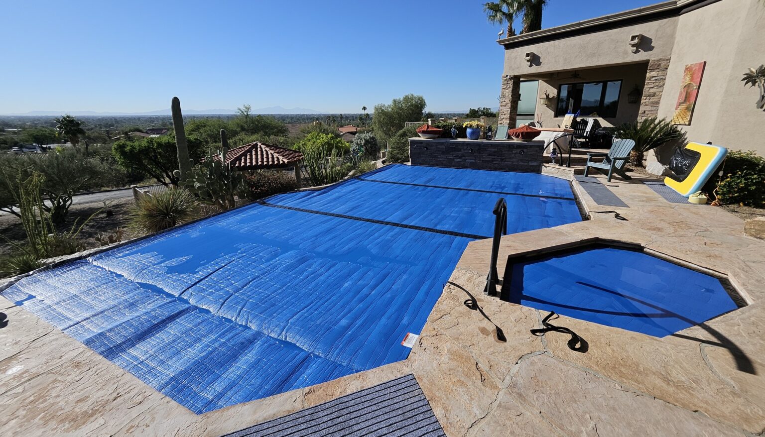 A HeatSaver thermal cover installed across a residential Arizona pool