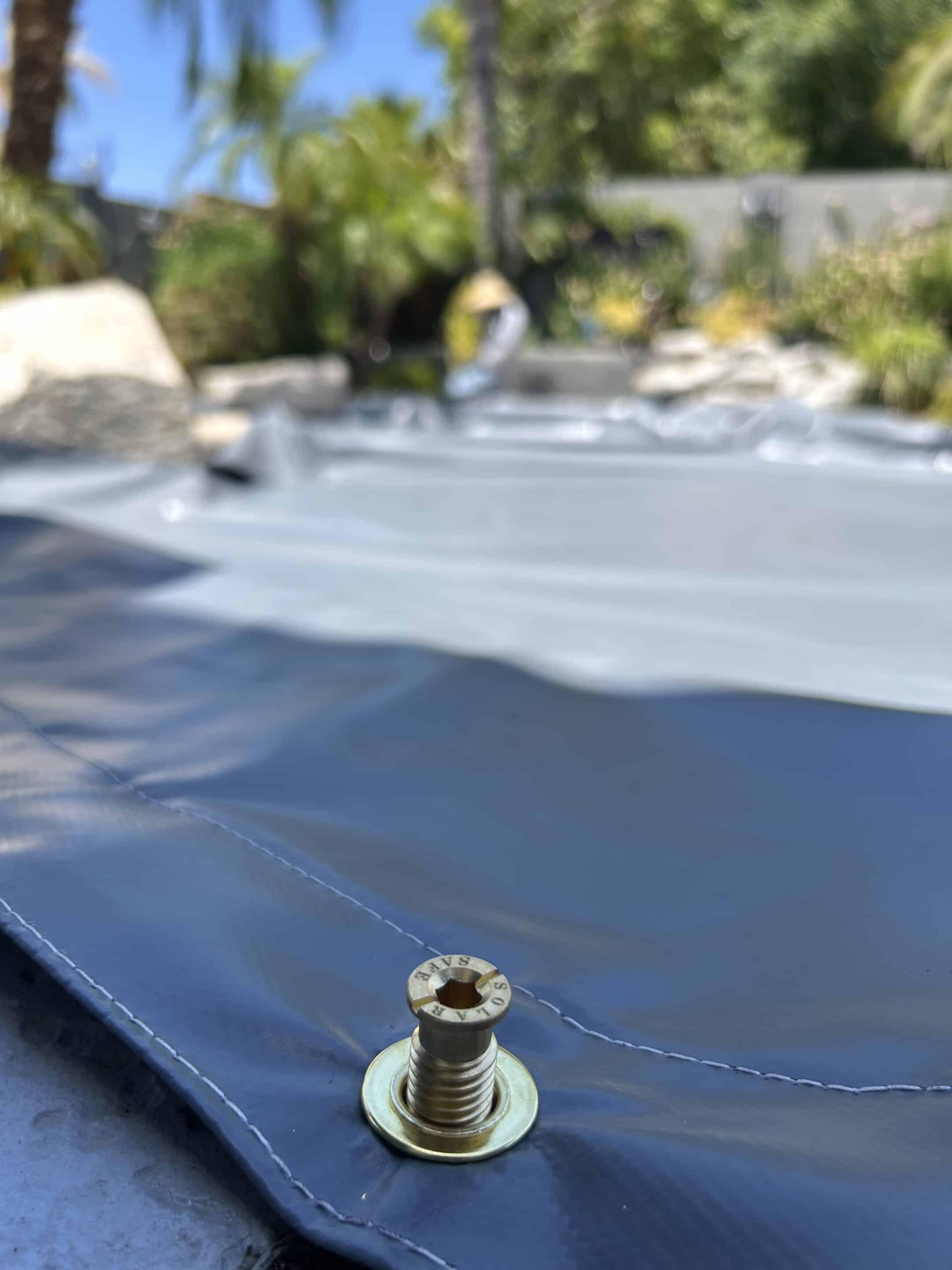 The PowerLock anchoring system holding the cover flush to the pool deck