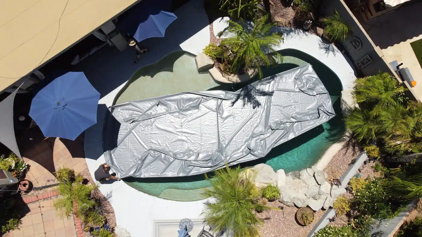 Drone view of a PowerLock cover being floated back across a pool